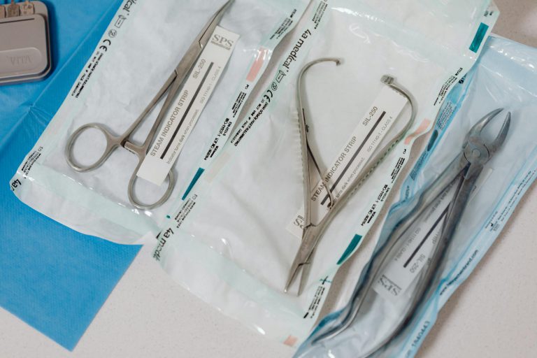 Close-up of sterilized surgical tools in packaging on a clinical table.